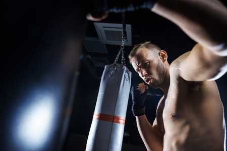 Male boxer fighting in the gym studioの写真素材