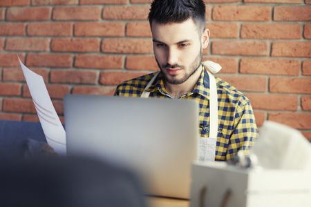 Focus waiter working with laptop in the barの写真素材