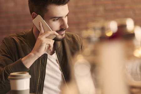 Close up of man calling in cafe barの写真素材