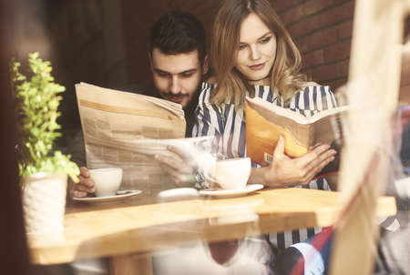 Young couple over reading in cafeの写真素材