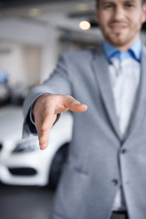 Car dealer reaching out his handの写真素材