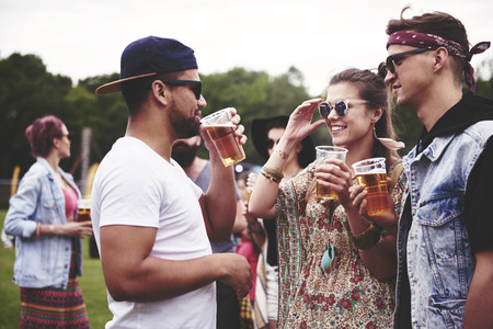 Group of friends drinking beer at the festivalの写真素材