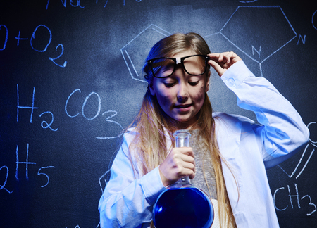 Blonde scientist looking at chemistry liquid