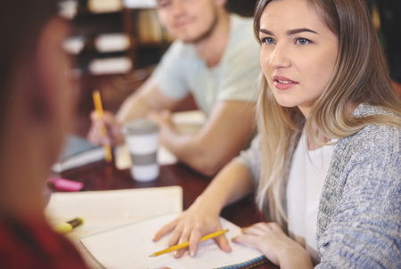 Student writing notes in public libraryの写真素材