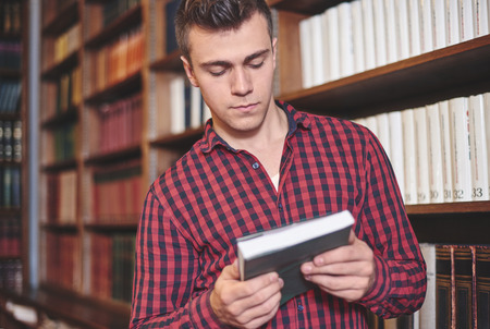 Handsome Man holding book in library