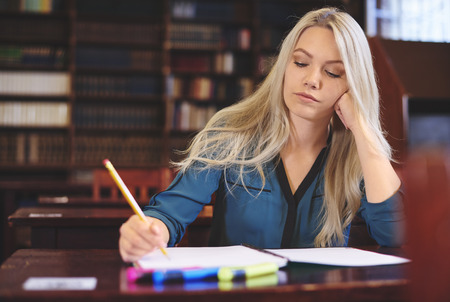 Young woman learning in libraryの写真素材