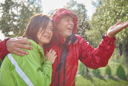 Senior couple embracing in rainの写真素材