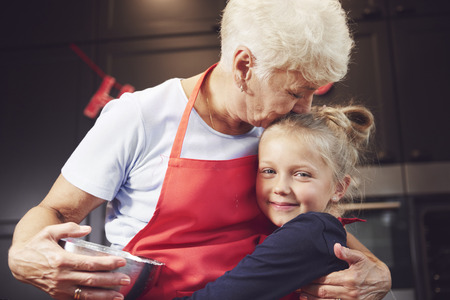 Grandmother kissing and hugging her granddaughterの写真素材