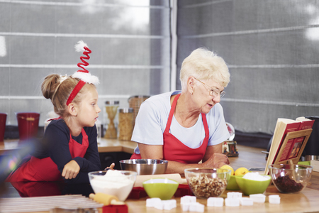 Grandmother and granddaughter preparing christmas cakeの写真素材