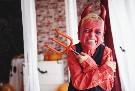 Boy in devil costume grimacingの写真素材