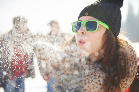 woman blowing the snow in front of cameraの写真素材