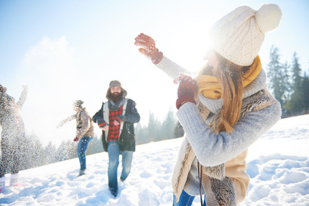 Young couple in snowball fightの写真素材