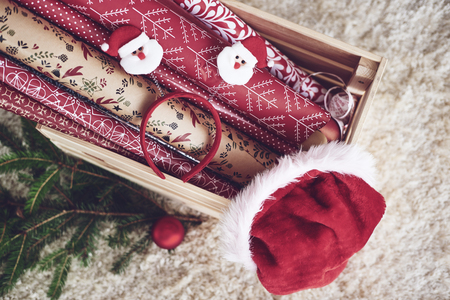 Wooden crate with christmas paper and santa hatの写真素材