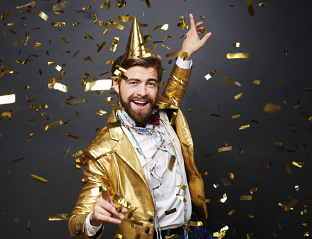 Businessman dancing among falling confettiの写真素材