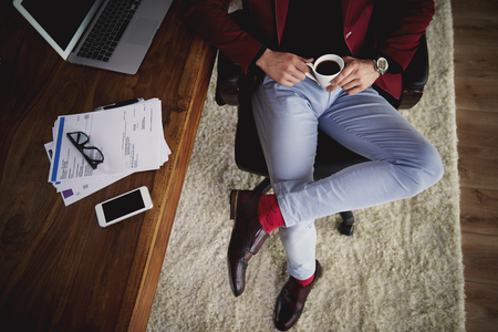 Unrecognizable businessman drinking coffee at his officeの写真素材