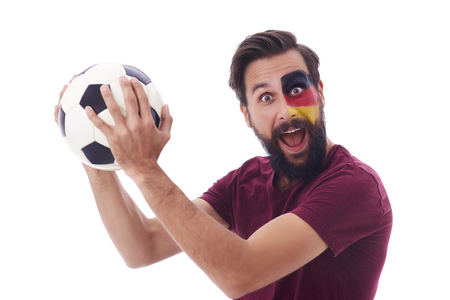 Cheerful soccer fan with soccer ball celebrtaing の写真素材
