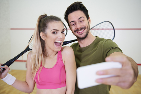 Squash friends taking a selfie on court の写真素材