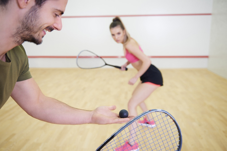 Couple playing squash at court の写真素材
