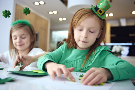 Portrait of siblings making ornament at irish party 
の写真素材