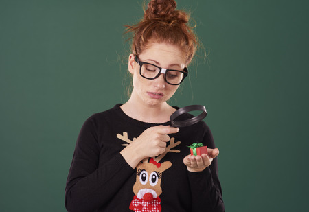 Disappointed woman looking at tiny presentの写真素材