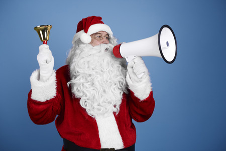 Santa claus with handbell shouting into megaphoneの写真素材