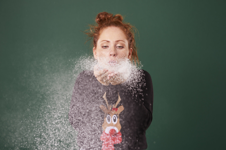 Young woman blowing fake snowの写真素材
