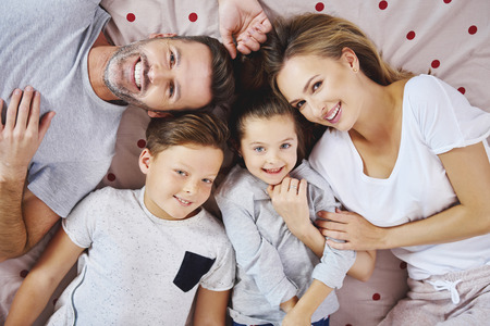 Portrait of happy family lying on the bedの写真素材