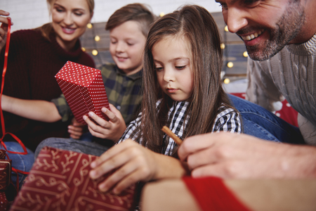 Close up of family opening christmas presents in bedの写真素材