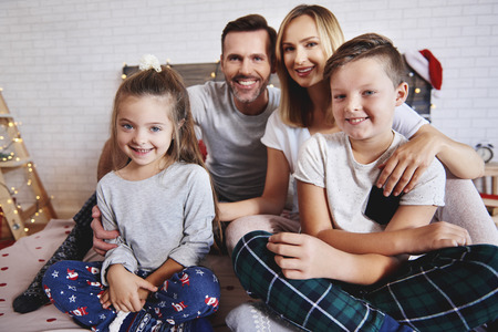 Portrait of happy family in bed at Christmasの写真素材