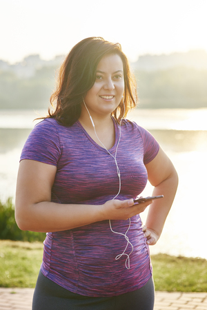 Woman listening to music by headphonesの写真素材