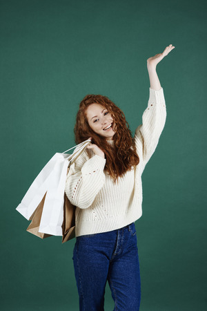 Smiling girl with shopping bags at studio shotの写真素材