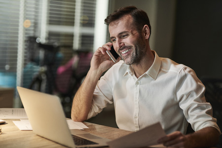 Smiling businessman talking by mobile phone