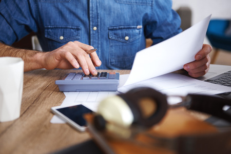 Man working with documents and calculator