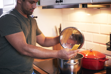 Young man preparing delicious dishesの写真素材
