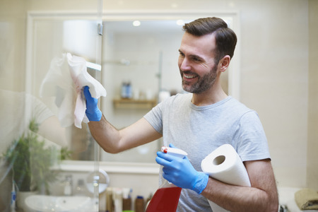 Happy man cleaning his home