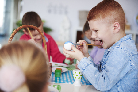 Screaming boy painting easter eggの写真素材