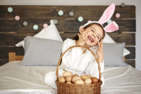 Happy girl with a basket of eggsの写真素材