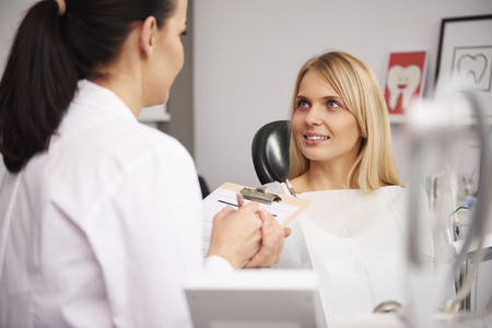 Dentist and patient discussing some medical record  の写真素材