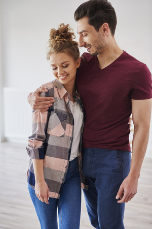 Happy couple embracing in their new homeの写真素材