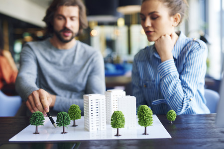 Architectural model and young adults architects in the backgroundの写真素材