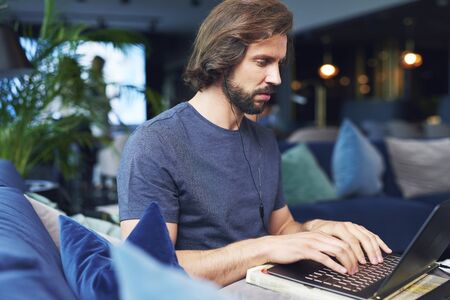 Focused man with headphones using a laptop