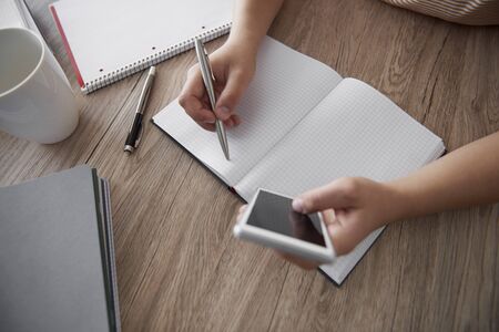 Womanâ€™s hand writing on notebook