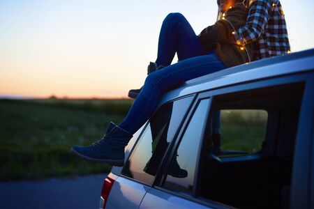 Loving couple embracing and sitting on carの写真素材