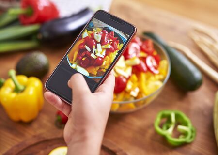 Taking picture of healthy saladの写真素材
