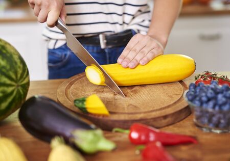 Woman cutting zucchini into slicesの写真素材