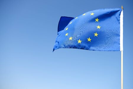 Waving European Union Flag on the blue backgroundの写真素材