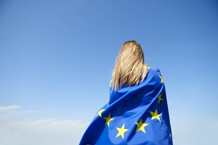 Rear view of young woman covered with European Union Flagの写真素材