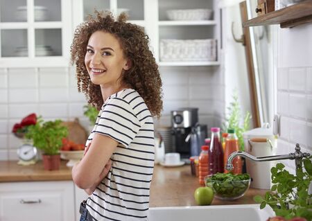 Smiling young woman in her kitchenの写真素材