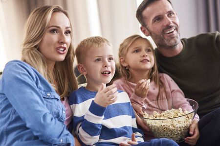Family with two children spending time together in living room の写真素材