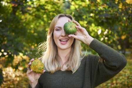 Portrait of woman having fun with pumpkin 